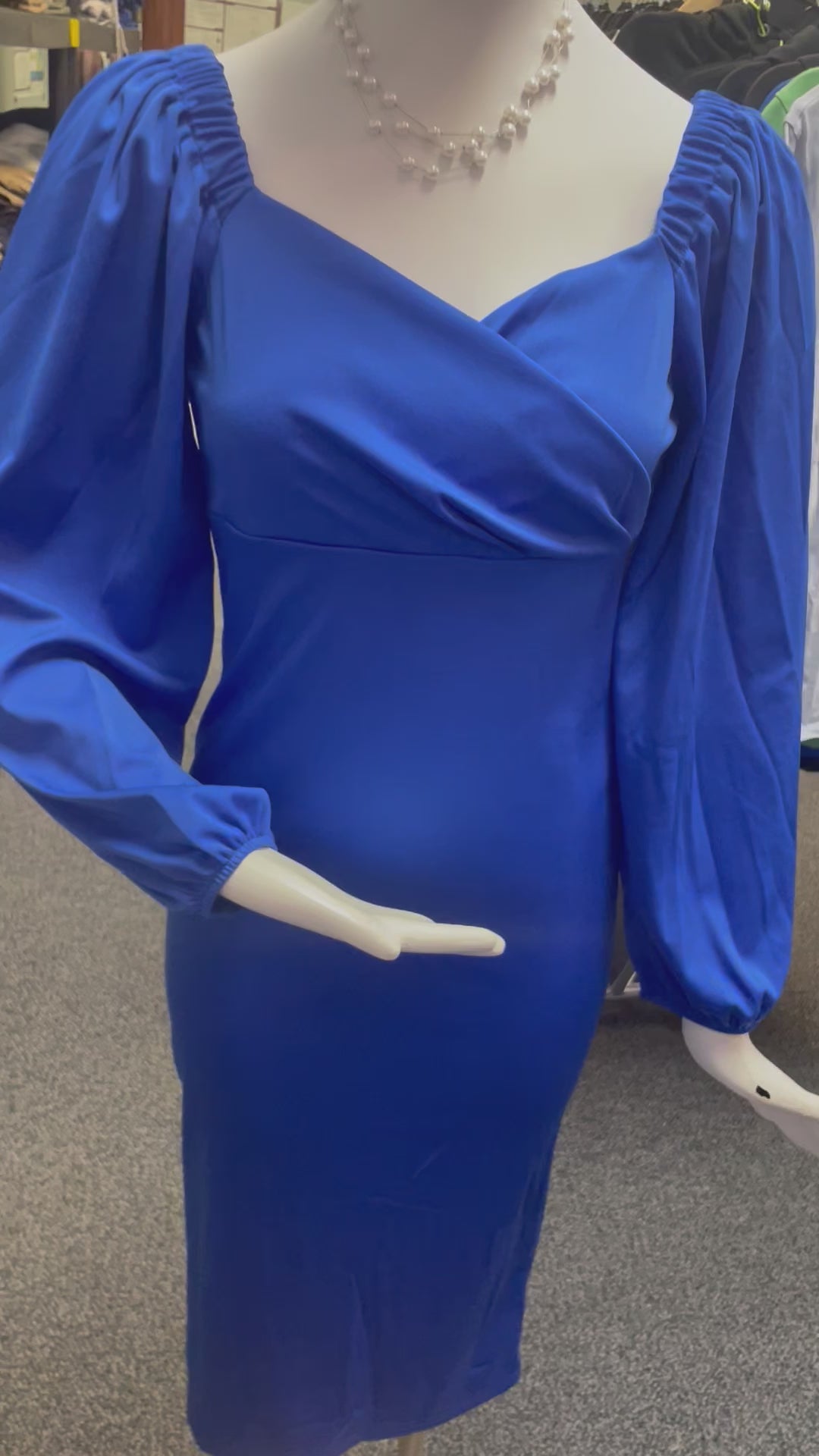 a mannequin dressed in a blue dress and necklace