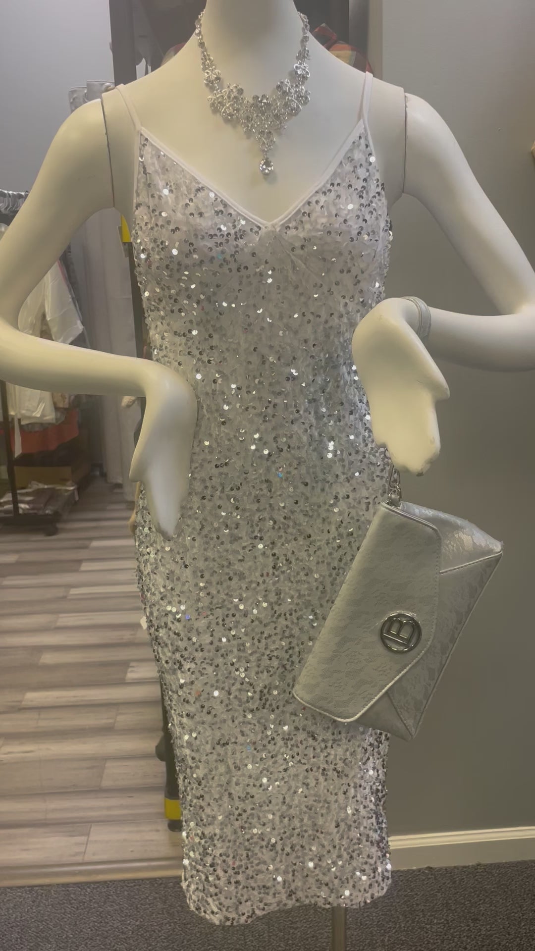 a mannequin wearing a silver dress and a necklace