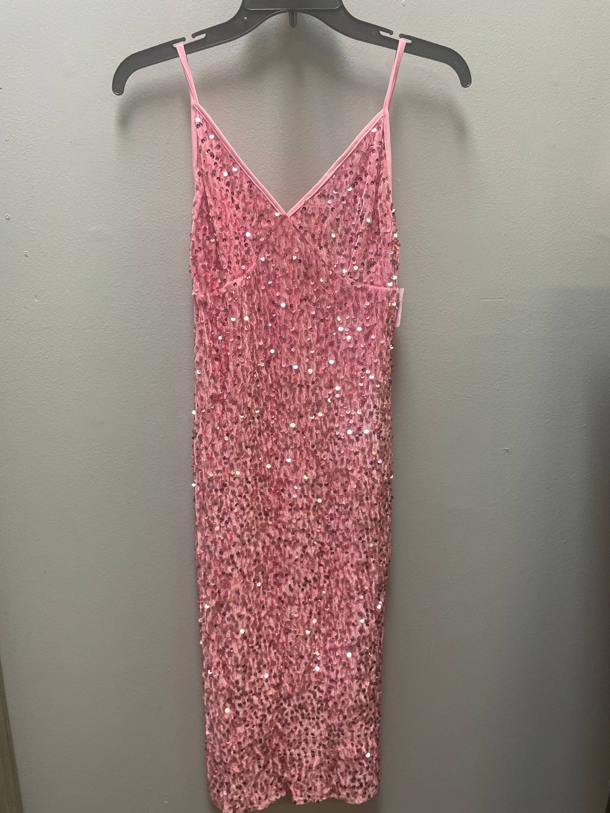 a pink dress hanging up against a wall